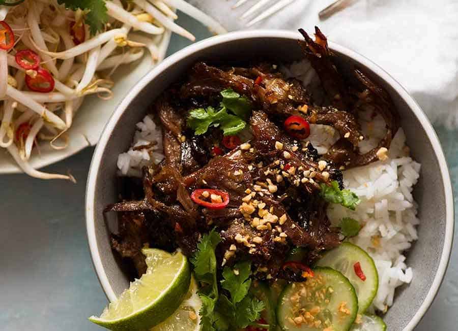 2 bowls of Caramelised Vietnamese Shredded Beef over rice with a side of bean sprouts and fresh herbs